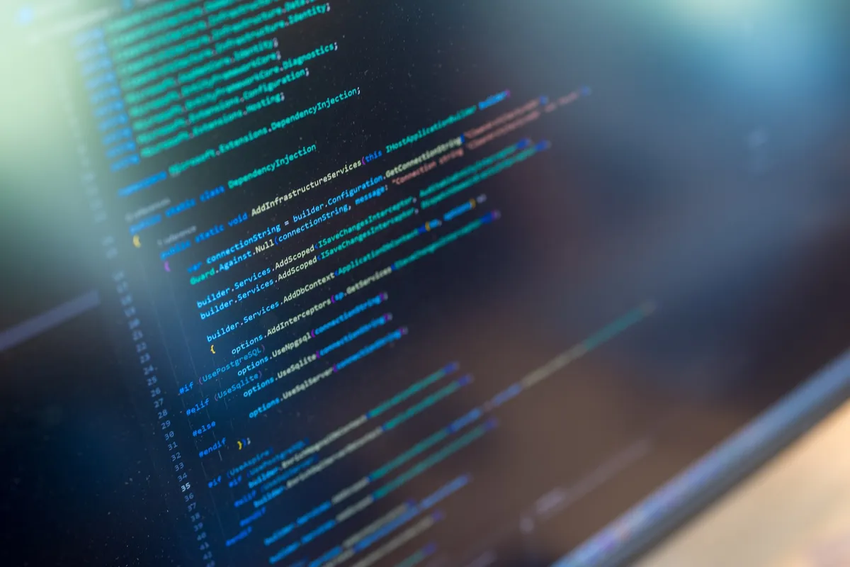 C#-code op monitor Close-up van een computerscherm met C#-broncode voor dependency injection en databaseconfiguratie in een donkere code-editor.